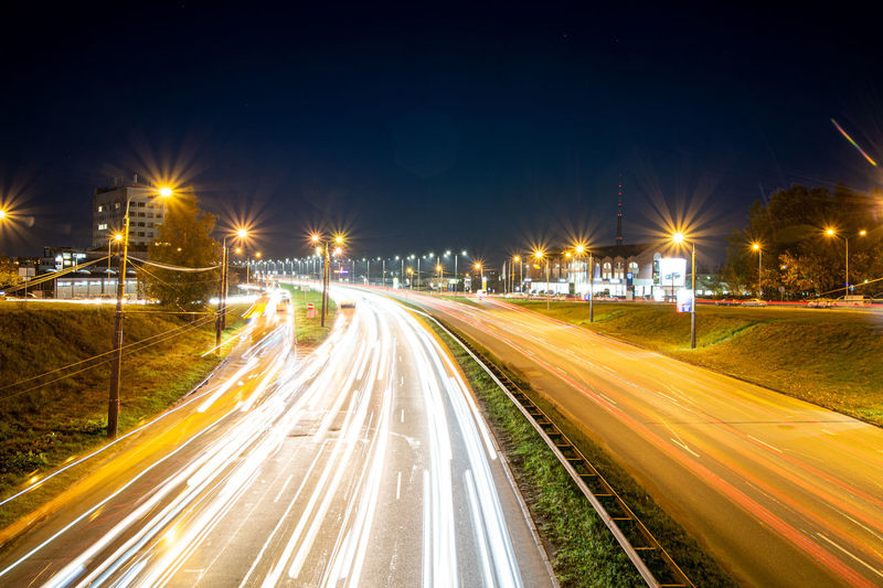 Light trails on road against sky at night