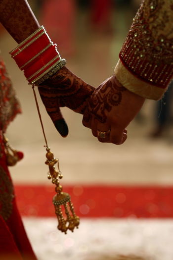 Cropped image if couple holding hands during wedding ceremony