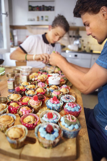 Young men making cupcakes