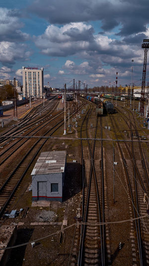 High angle view of railroad tracks by buildings in city against sky