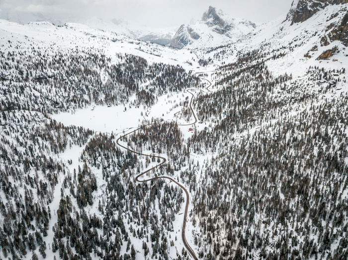 High angle view of winding road amidst snow covered land