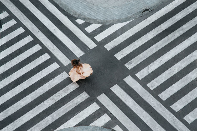 Woman dancing in a zebra crossing with a dress