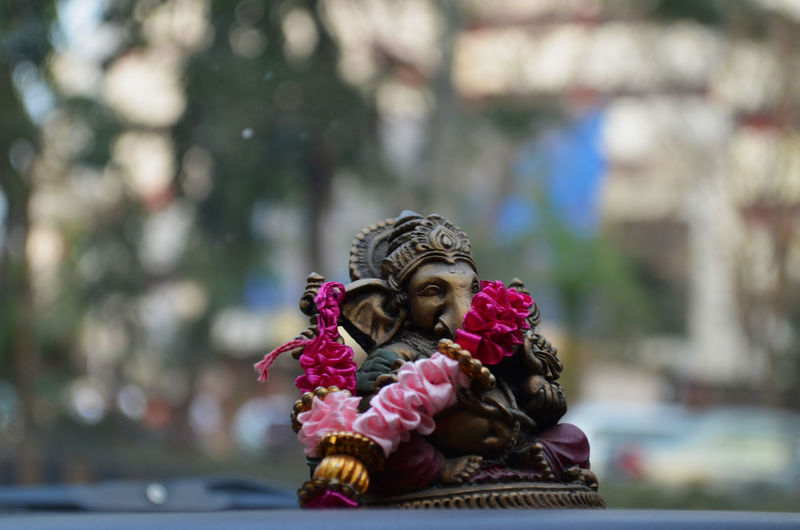 Close-up of ganesha figurine on car dashboard
