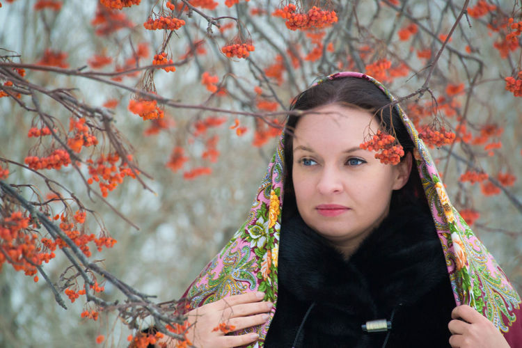 Portrait of beautiful young woman standing against tree during autumn