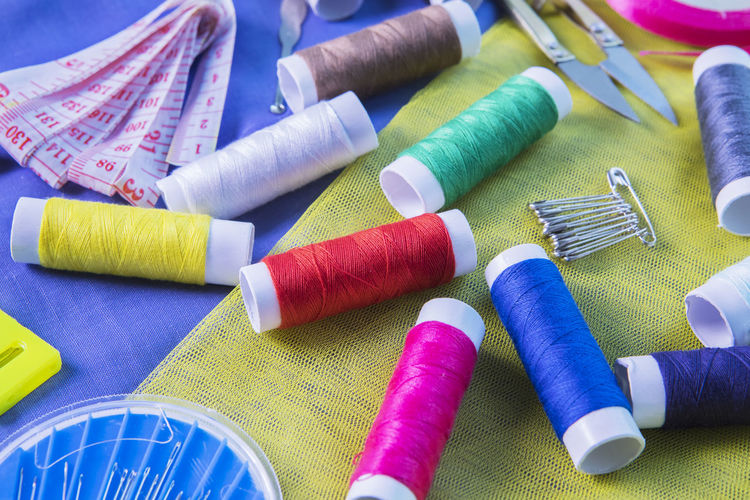 High angle view of colorful sewing items on fabric