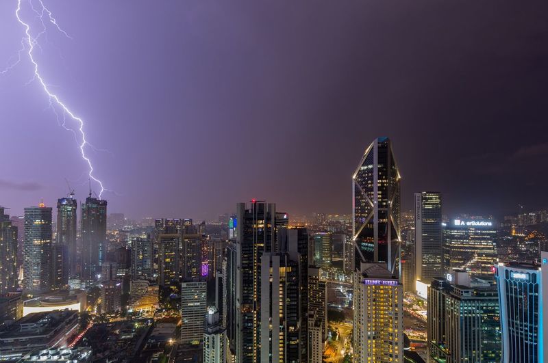 Panoramic view of illuminated buildings against sky at night