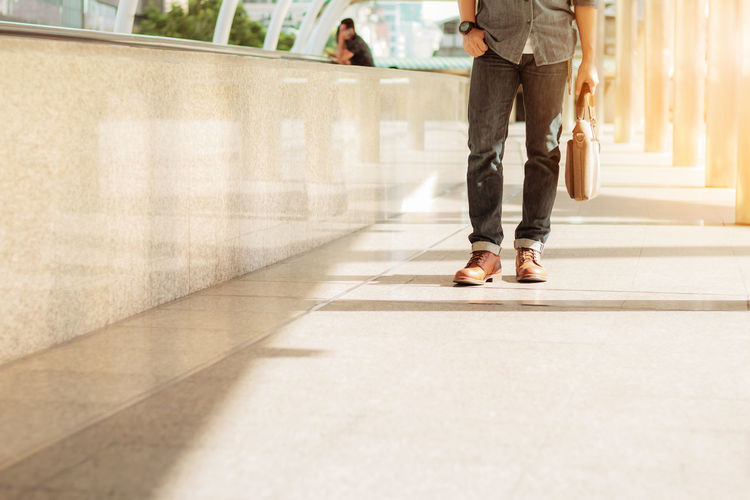 Low section of man standing on corridor