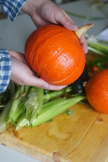 Cropped hand of man holding pumpkin