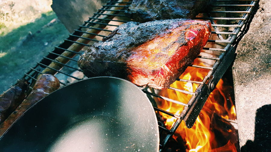 High angle view of meat and cooking pan on barbecue