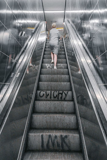 Rear view of woman on escalator