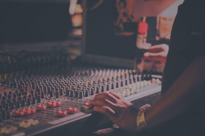 Midsection of man mixing sound in recording studio