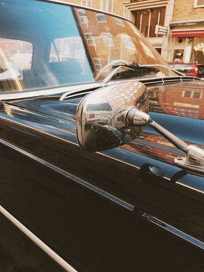 Close-up of vintage car with reflection of buildings