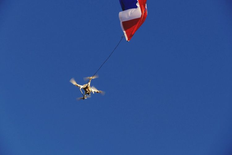 Low angle view of kite flying against clear blue sky