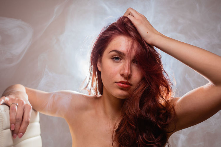 Portrait of beautiful young woman with hand in hair
