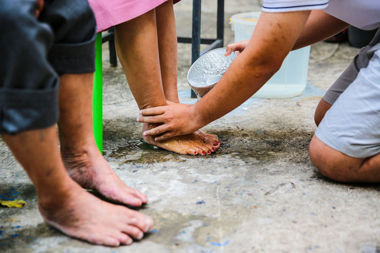 Midsection woman washing parents feet