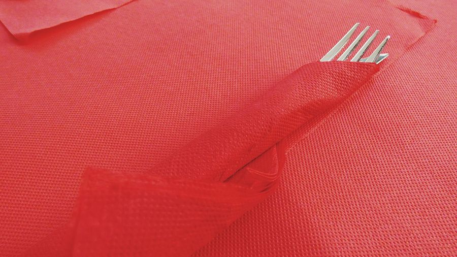 Table knife and fork covered in red napkin on restaurant table