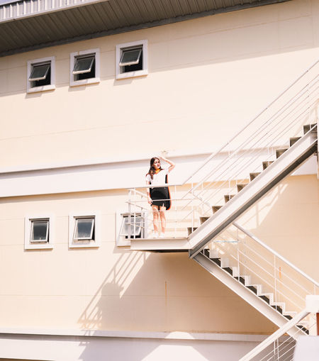 Low angle view of woman on staircase of building