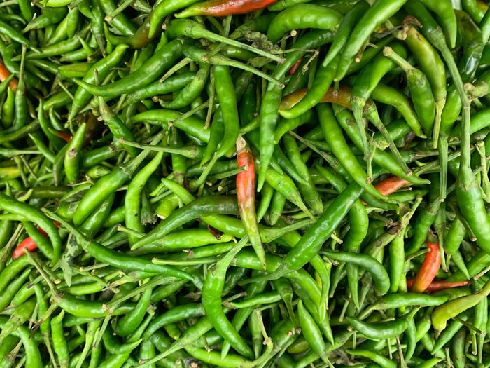 Full frame shot of green chili peppers for sale in market