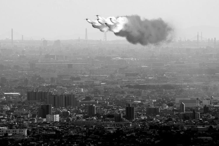 Japan air self defense force aerobatic team blue impulse flying in formation over the city