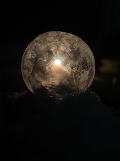 Close-up of illuminated ball against black background