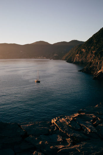 Scenic view of a boat in a sea at sunset, cinque terre, italy.