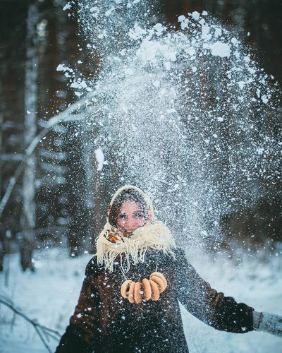 Woman playing with snow on field