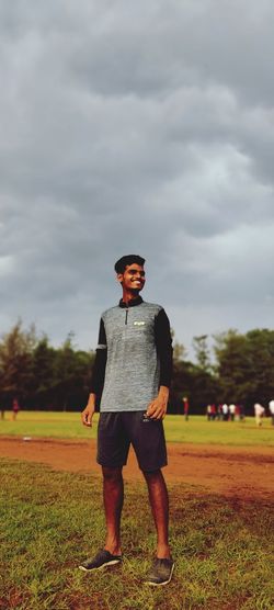Full length portrait of man standing on field against sky