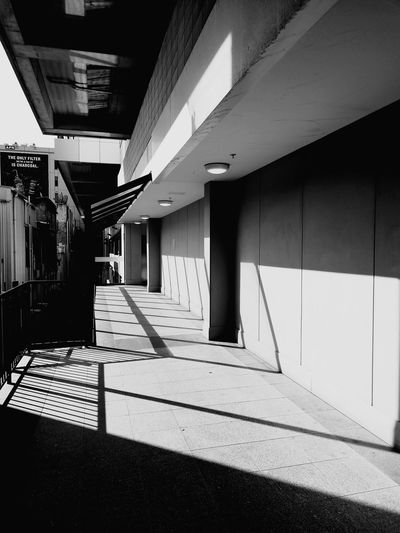 Empty footpath amidst buildings in city