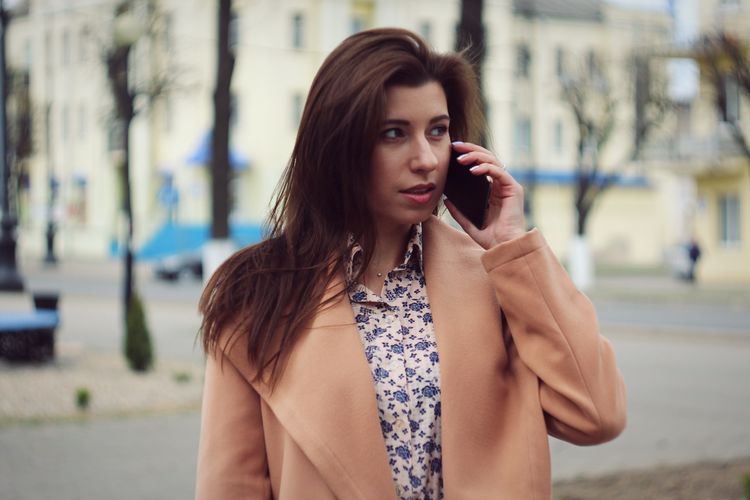 Woman talking on mobile phone in city
