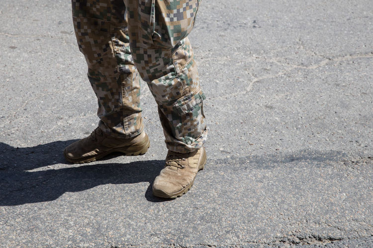Low section of soldier standing on road