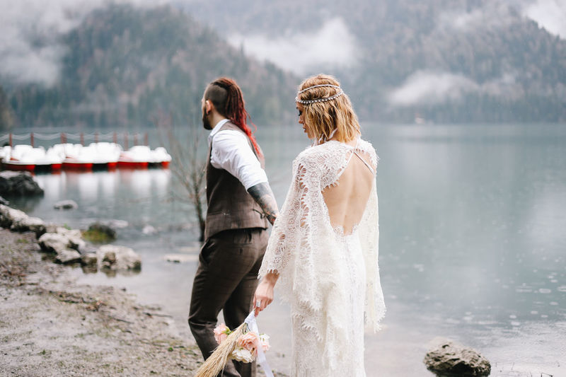 A happy couple in love and married embrace in nature by the lake and the misty mountains
