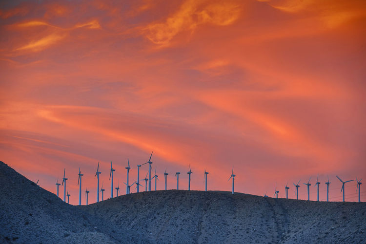 Low angle view of windmills of mountain peak during sunset