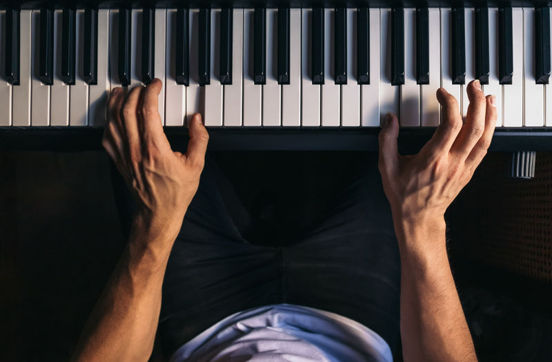 Midsection of man playing piano