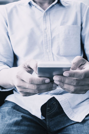 Midsection of man using phone