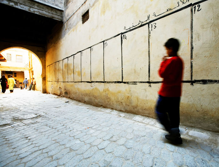 Blurred motion of boy walking by election wall