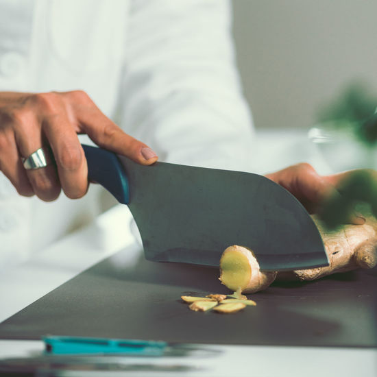 Cropped image of female chef preparing food in commercial kitchen