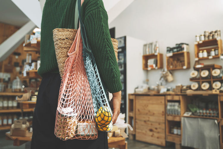 Customer carrying groceries in mesh bag at shop