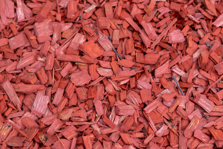 Shredded red wood chips fragments as red woodpath with timber shavings and recycled