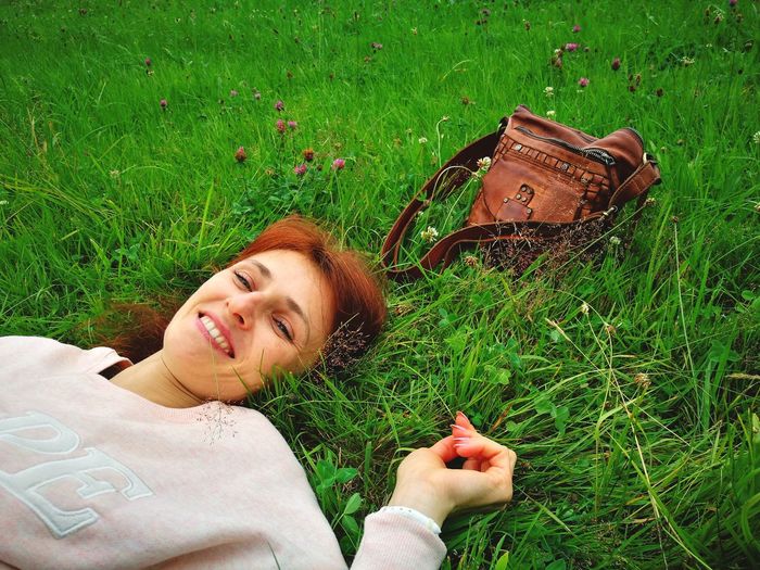 Portrait of young woman lying on grass