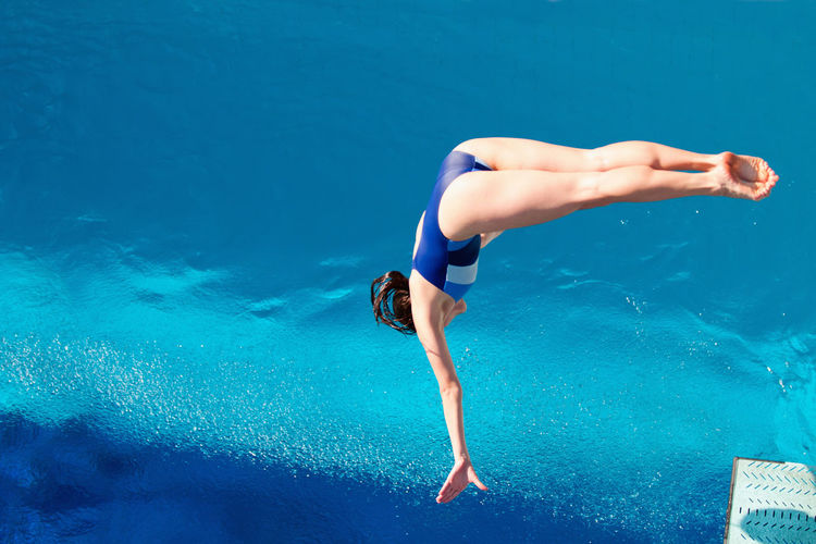 High angle view of woman jumping in swimming pool