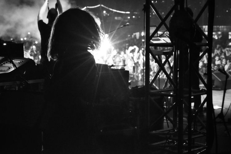 Rear view of silhouette person standing at music concert