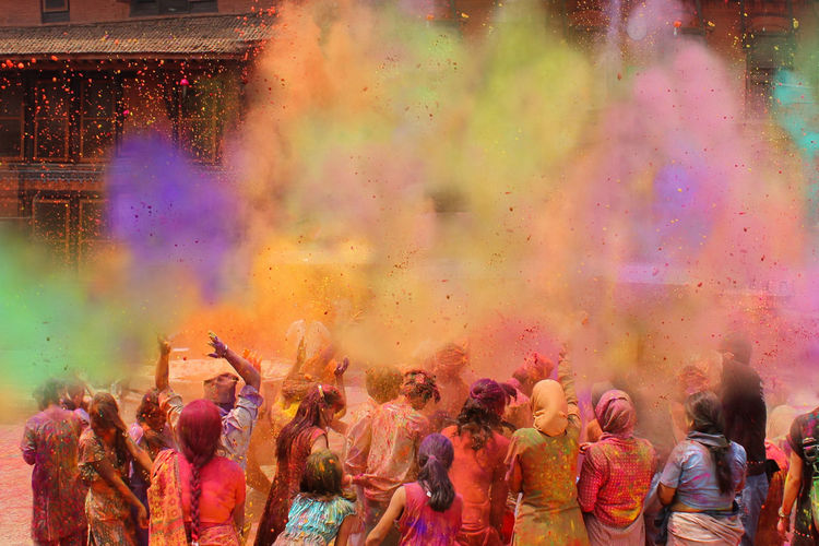 People playing with powder paint during holi in city