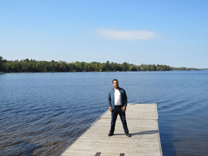 Full length of man standing by river on jetty
