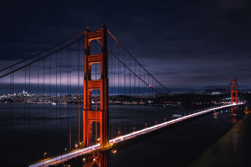 Golden gate bridge over bay against sky at night