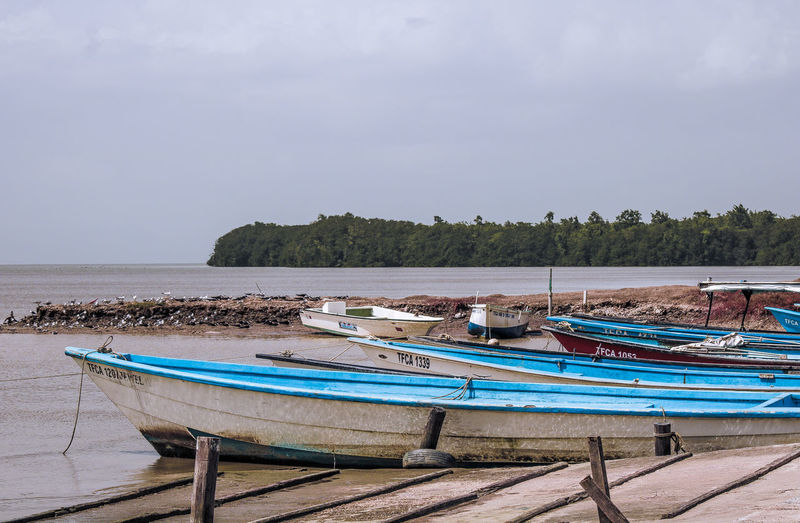 Boats moored on sea against sky