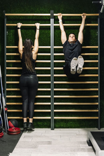 Couple stretching in the gym in the espalier