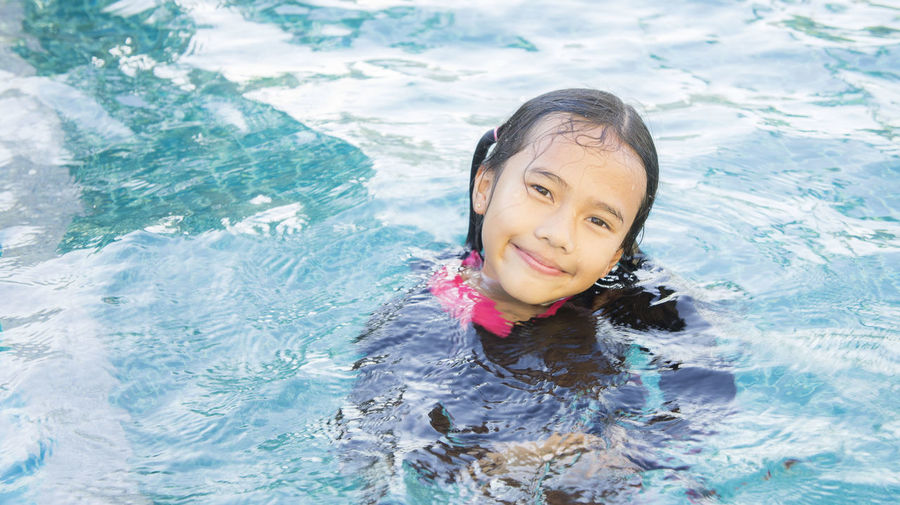 Portrait of smiling girl swimming in pool