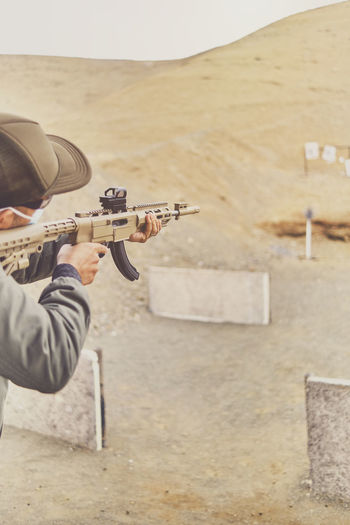 Men practicing shooting with a assault rifle at target. selective focus