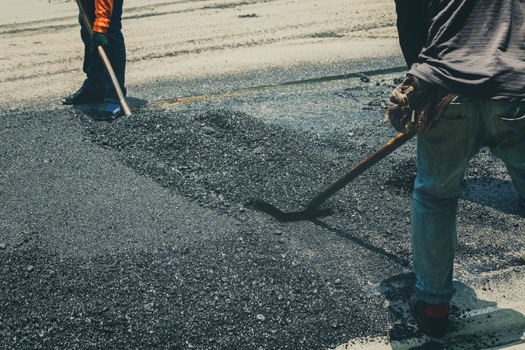 Low section of people working on road in city