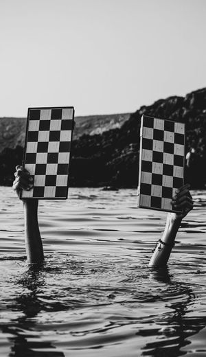 Tow hand in sea with chess board .
